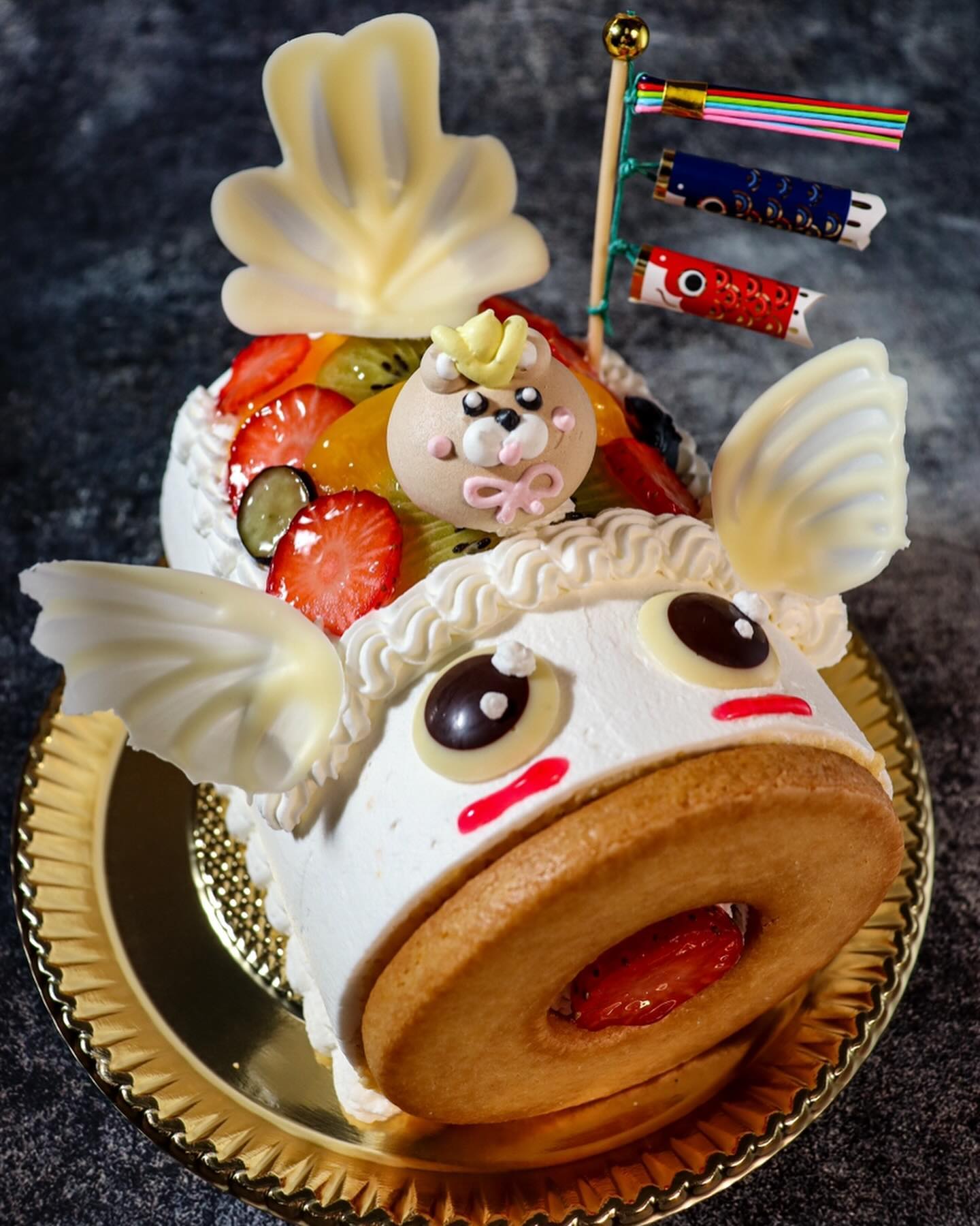 こどもの日限定ケーキのご紹介です

〜　こいのぼりロール　〜
　　　　　　　　12㎝　　¥2600 税込
ふわふわのロール生地で苺・キウイ・甘夏を巻き込み
表面にも黄桃・キウイ・苺・ブルーベリーで彩りよく飾った
鯉のぼり型ロールケーキです。
愛らしい表情のこいのぼりの上には、メレンゲで作った
兜クマさんをのせました。

数に限りがございますので、
ぜひご予約をおすすめしております
よろしくお願い致します。
皆様のお越しをスタッフ一同心より
お待ちしております

ル・クレールのクレープ屋さんカフェ・ド・バルーンで
焼き立てクレープをご用意しております。
是非よろしくおねがい致します